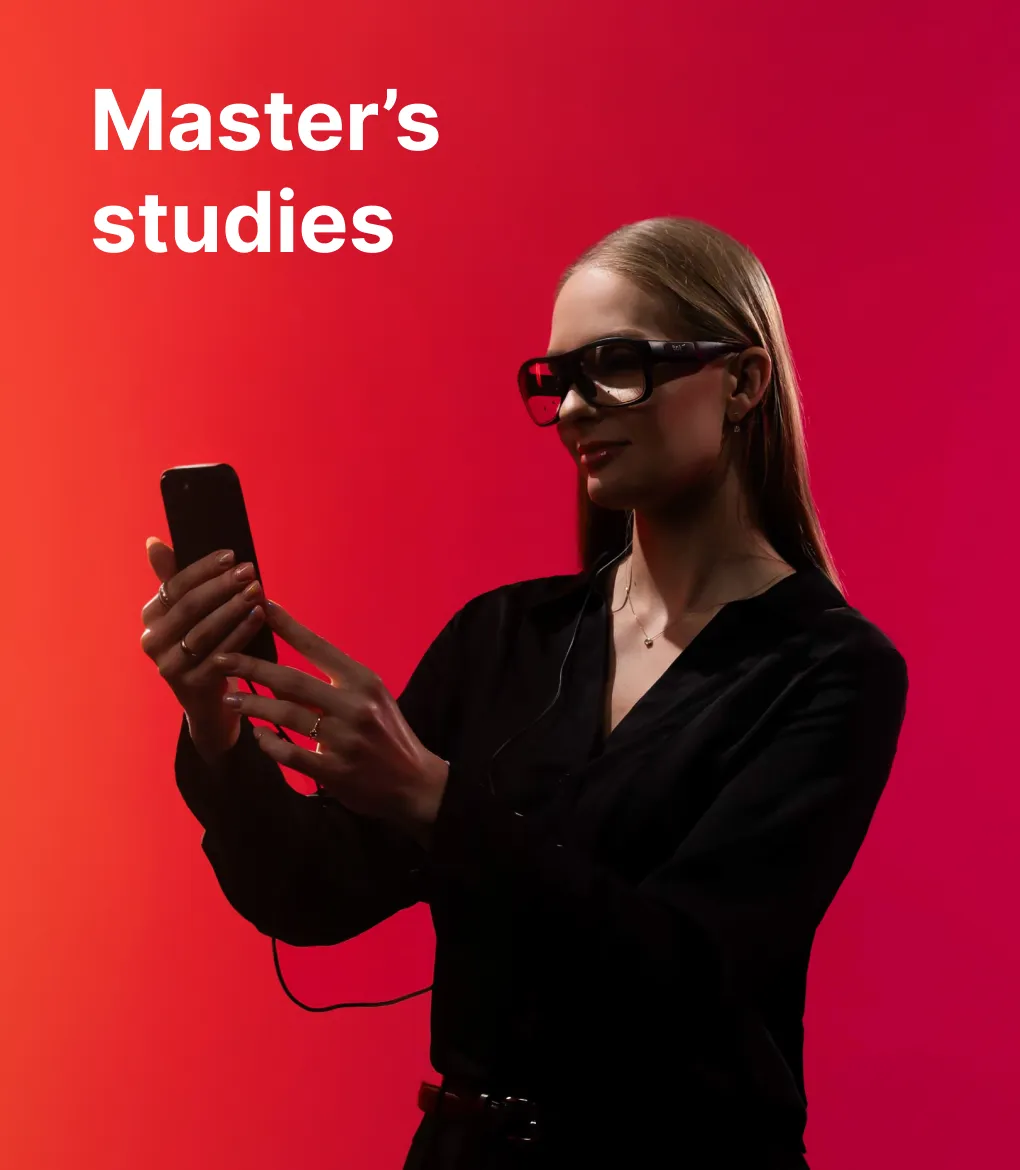 A KTU Faculty of Social Sciences, Humanities and Arts student working with a smartphone and wearing smart glasses against an orange and red decorative background. The faculty offers master's studies. Choose KTU master's studies.