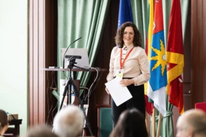 Woman scientist on the stage with flags on the background